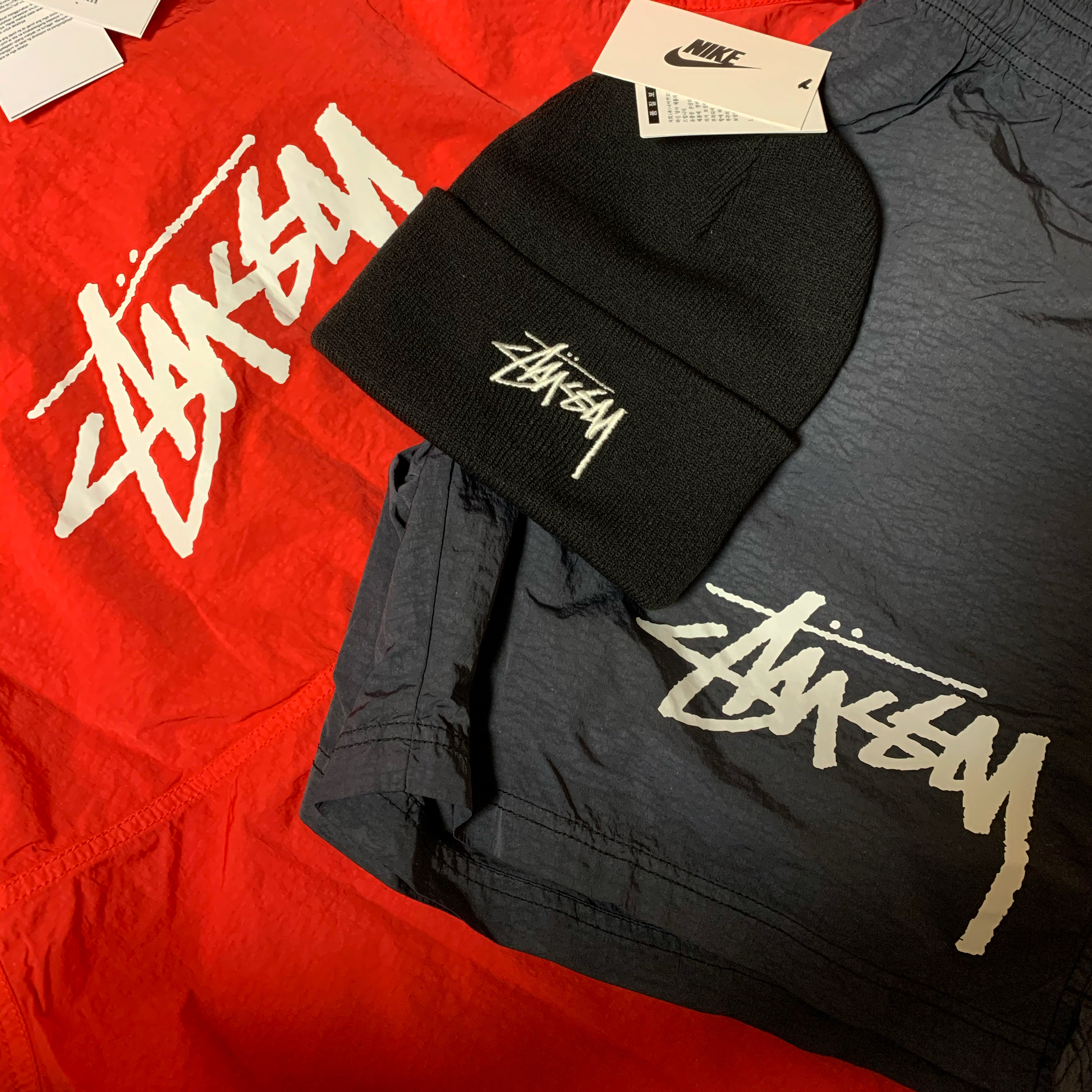 Nike x Stussy Cuff Beanie Black, Nike x Stussy Windrunner Jacket Habanero Red 착용 스타일