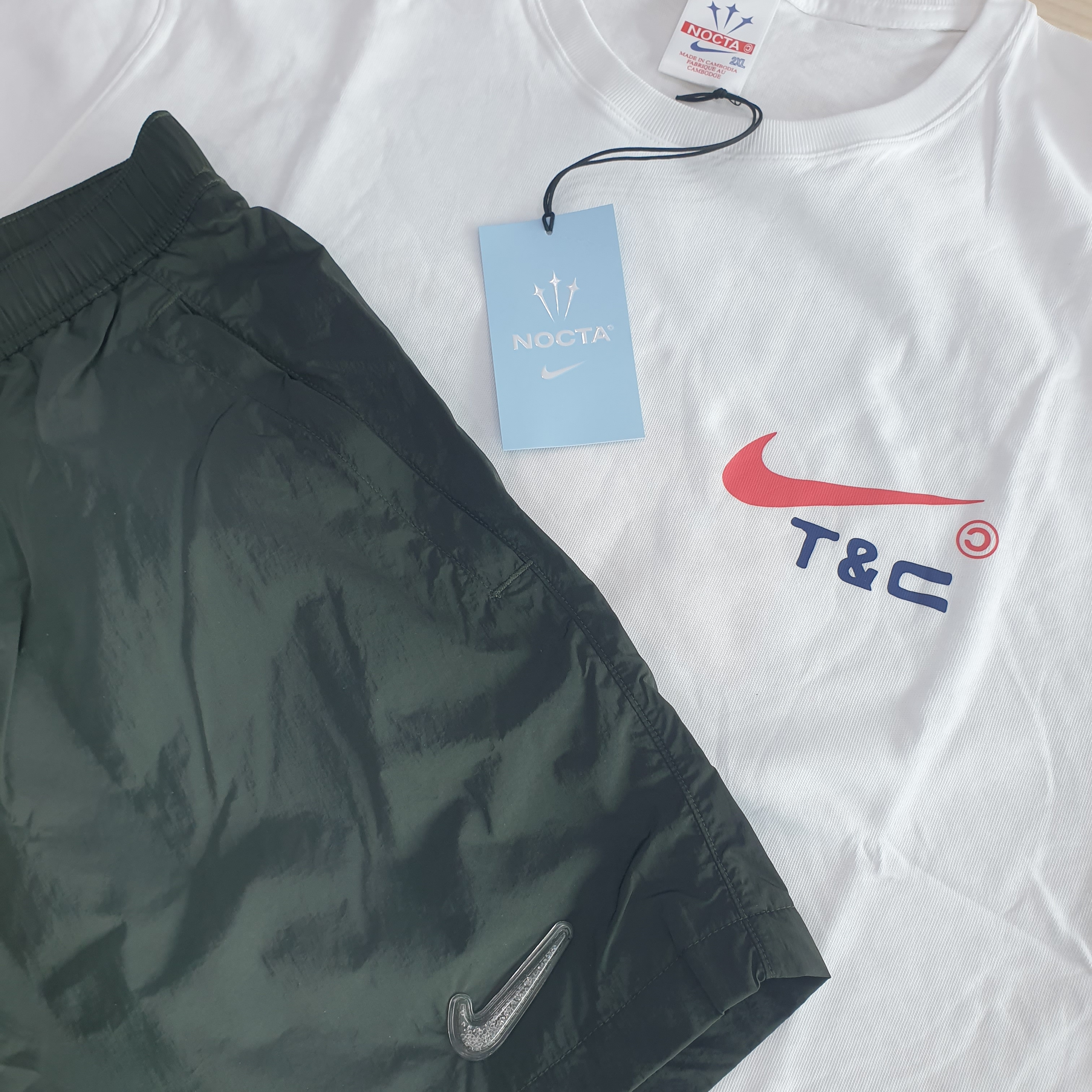 Nike x Drake Nocta x Cactus Plant Flea Market Souvenir Cactus T-Shirt White (DR2630-100), Nike x Drake Nocta Shorts Sequoia (DR2628-355) 착용 스타일