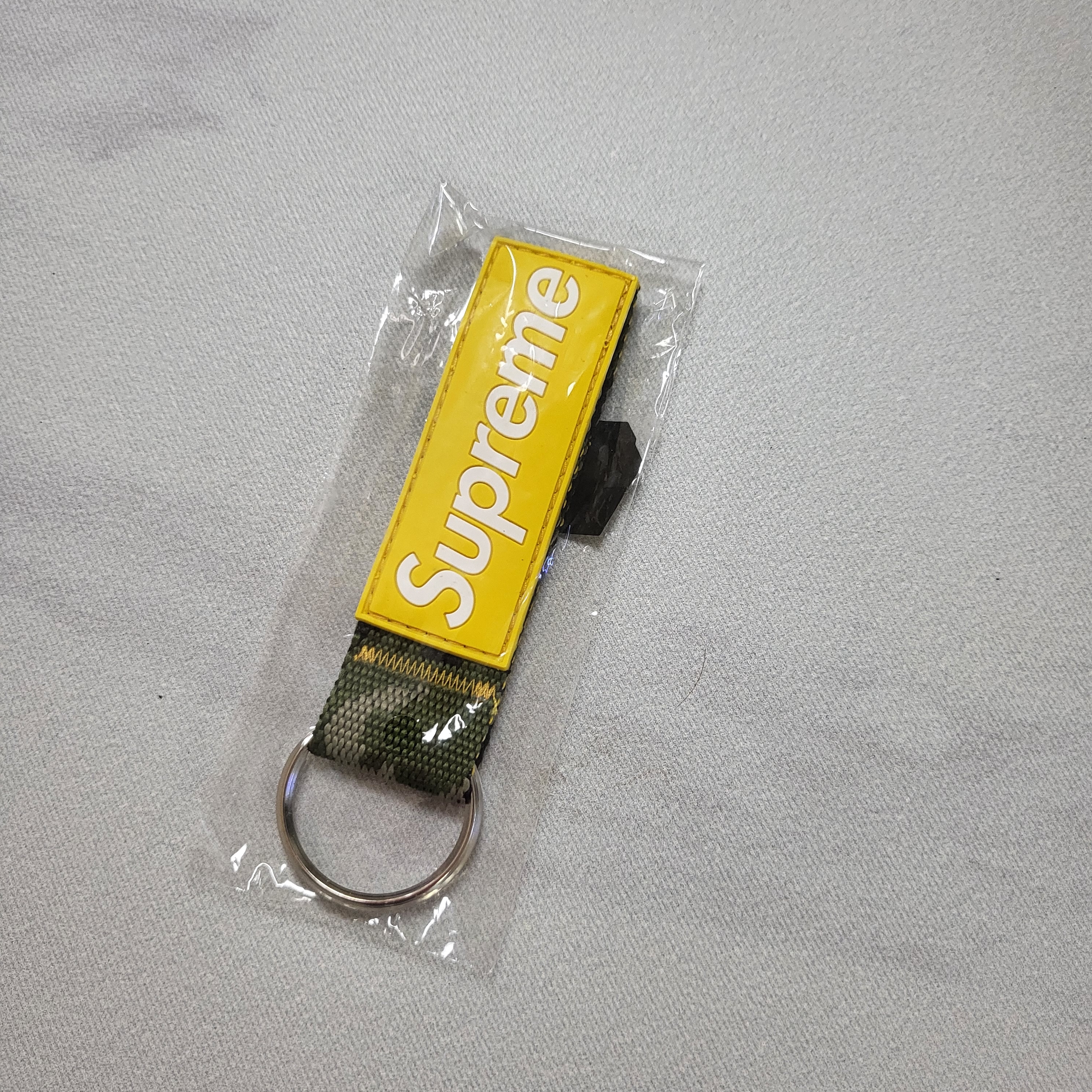 Supreme Webbing Keychain Yellow Camo - 23SS 착용 스타일