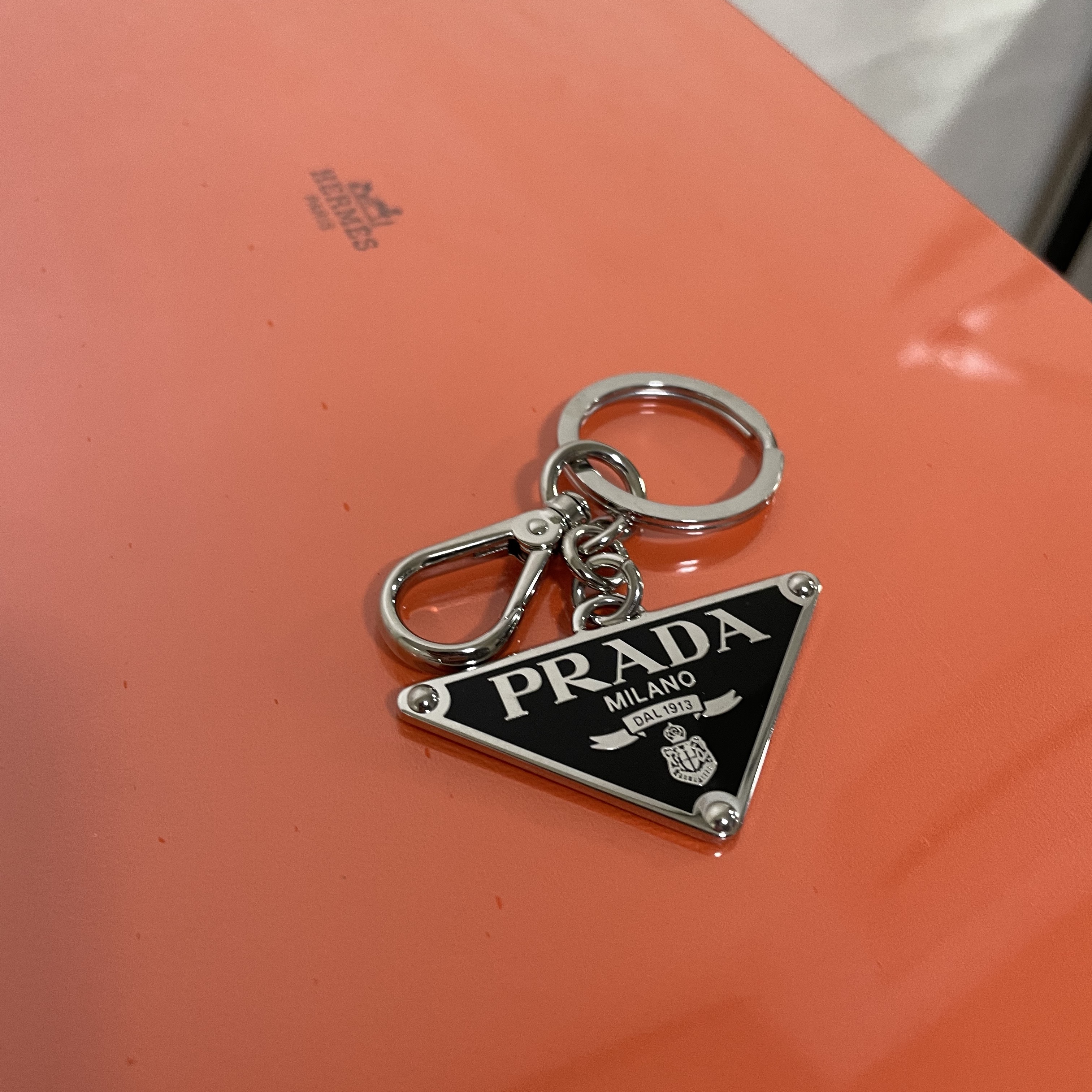 Prada Saffiano Leather Triangle Logo Keychain Black Silver, Prada Re-Nylon and Saffiano Leather Backpack Black 착용 스타일 - 1