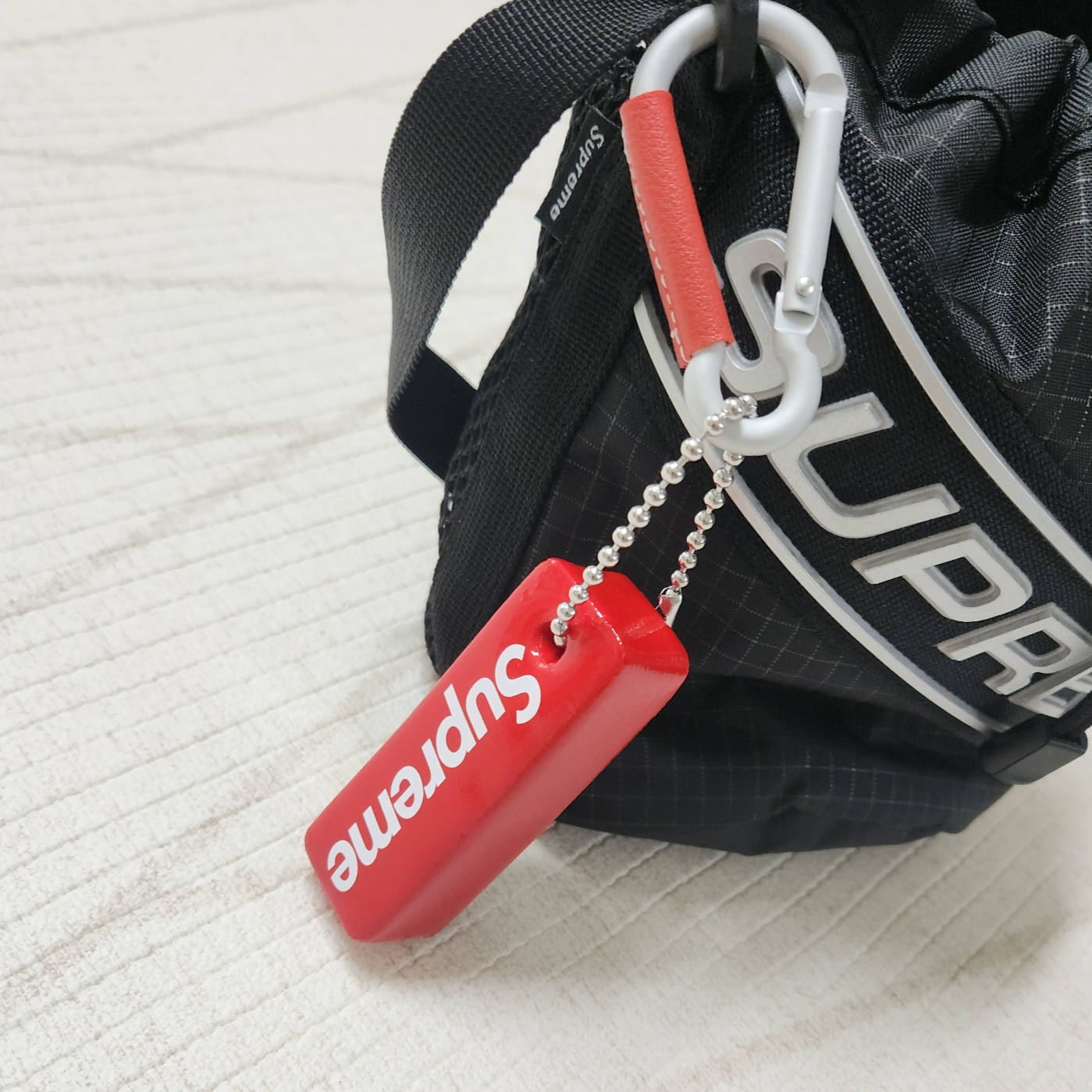Supreme Small Cinch Pouch Black - 23FW, Supreme Floating Keychain Red - 23FW 착용 스타일 - 2