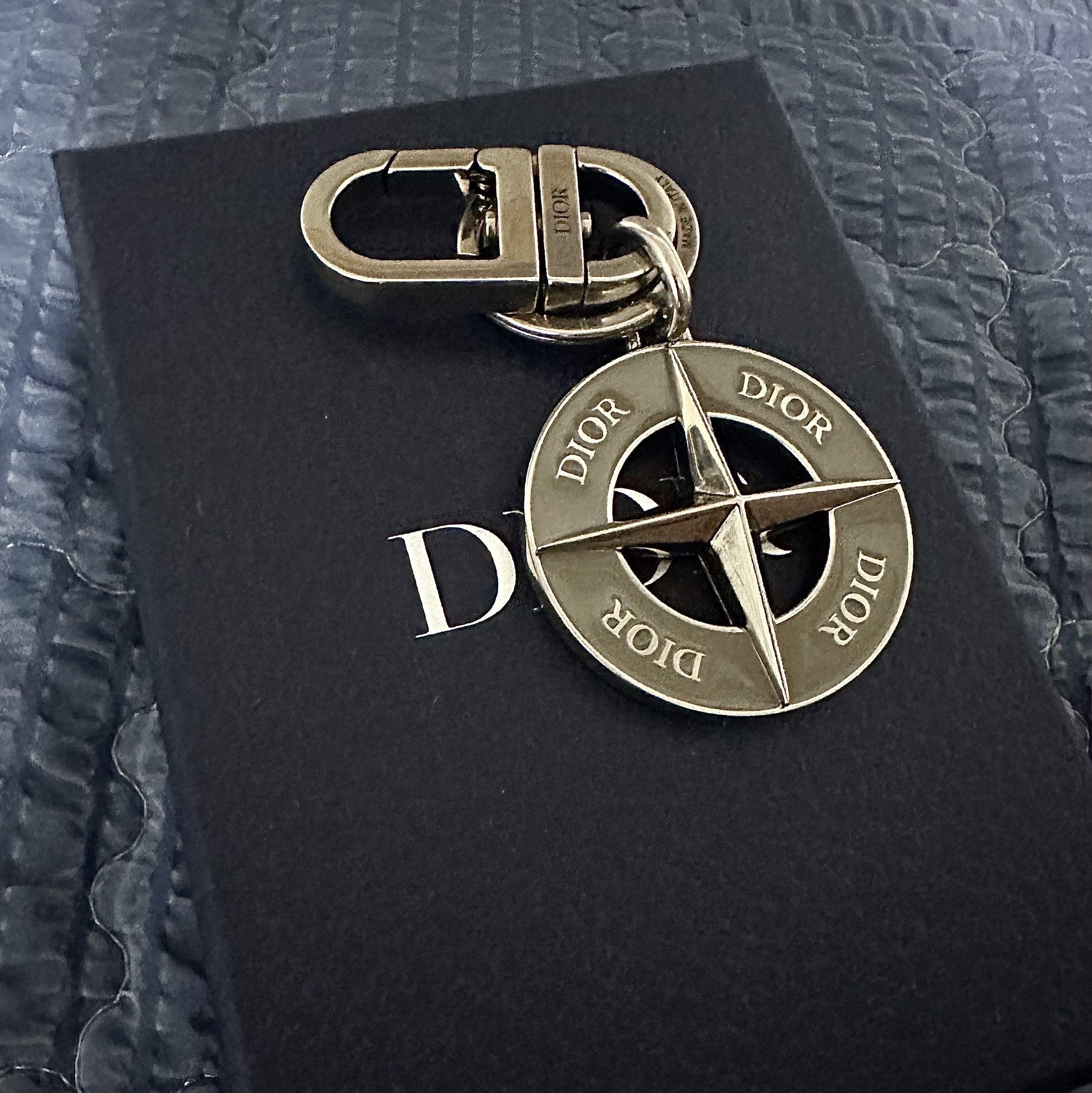 Dior x Stone Island Key Ring Palladium Finish Brass and Gray Enamel, Dior Saddle Pouch with Strap Grained Calfskin Beige & Black Dior Oblique Jacquard Black 착용 스타일 - 1