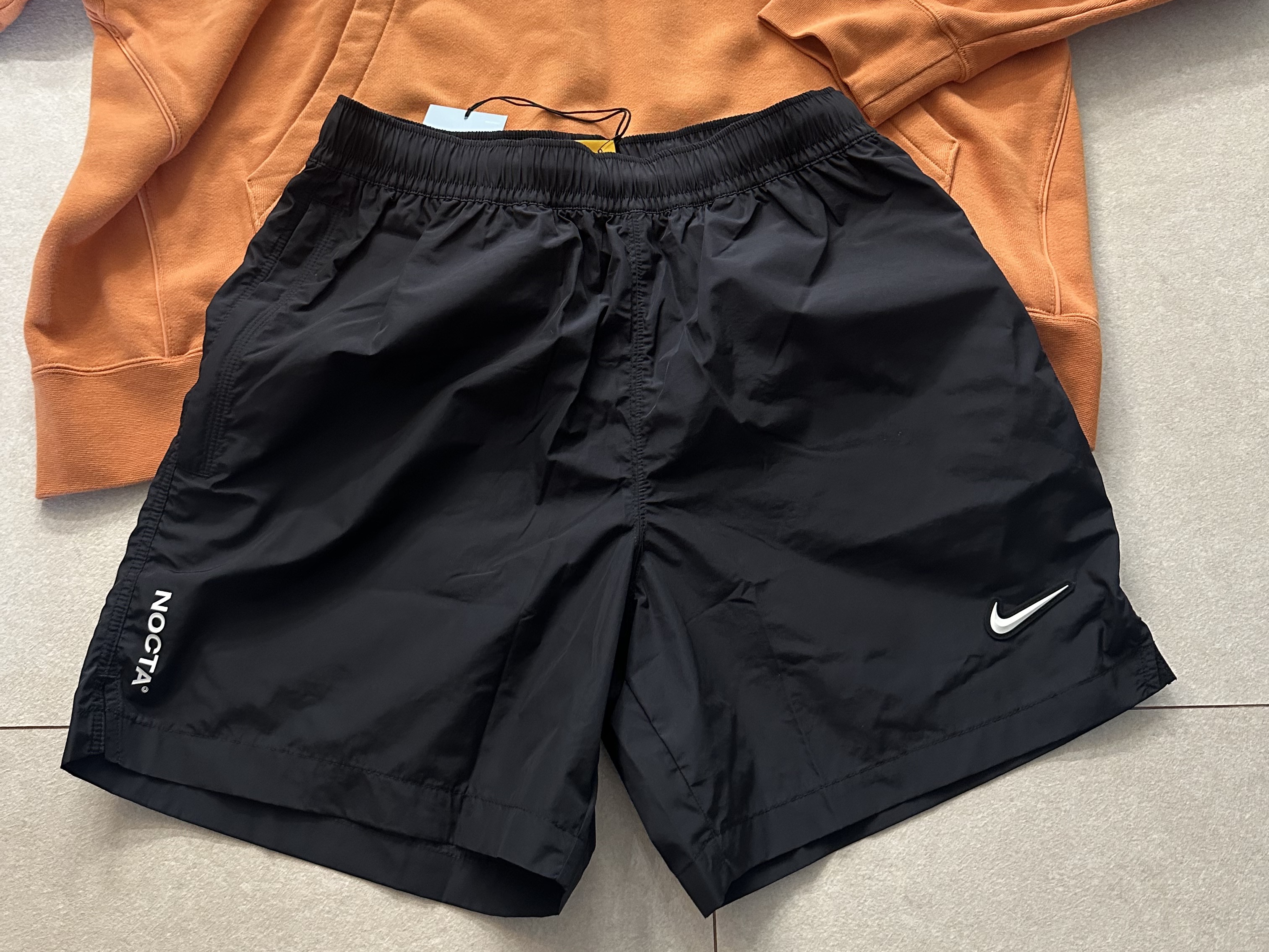 Nike x Drake Nocta Nylon Woven Shorts Black (FN8194-010), Nike x Drake Nocta Fleece Hoodie Hot Curry (FN7659-808) 착용 스타일 - 1