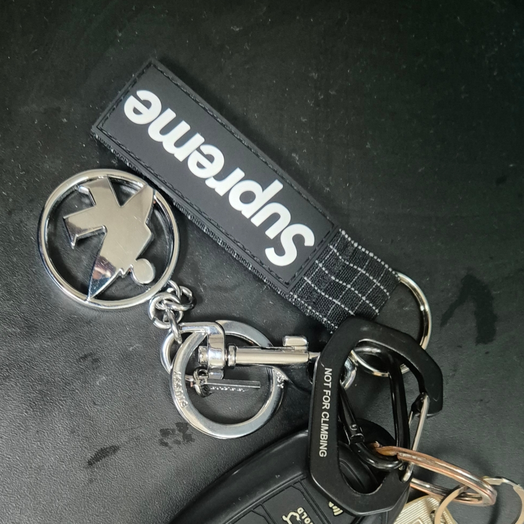 Stussy Surfman Keychain Silver, Supreme Ripstop Keychain Black - 24SS 착용 스타일