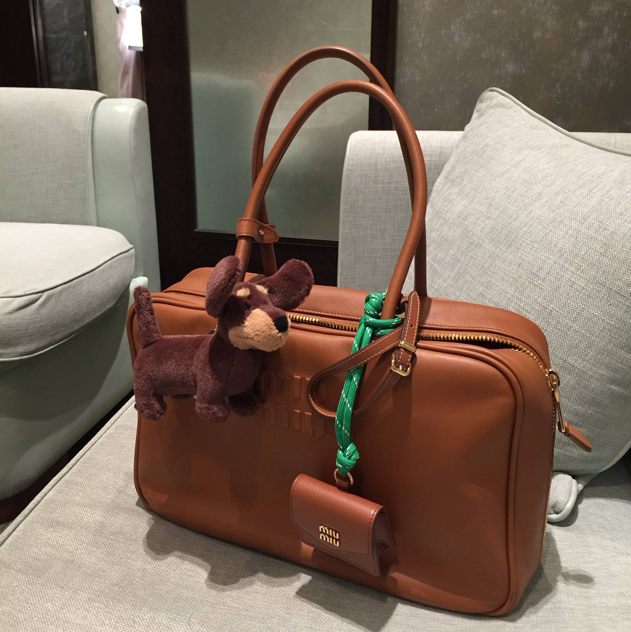 Miu Miu Leather Top Handle Bag Cognac, Jellycat Otto Sausage Dog Bag Charm Brown 착용 스타일