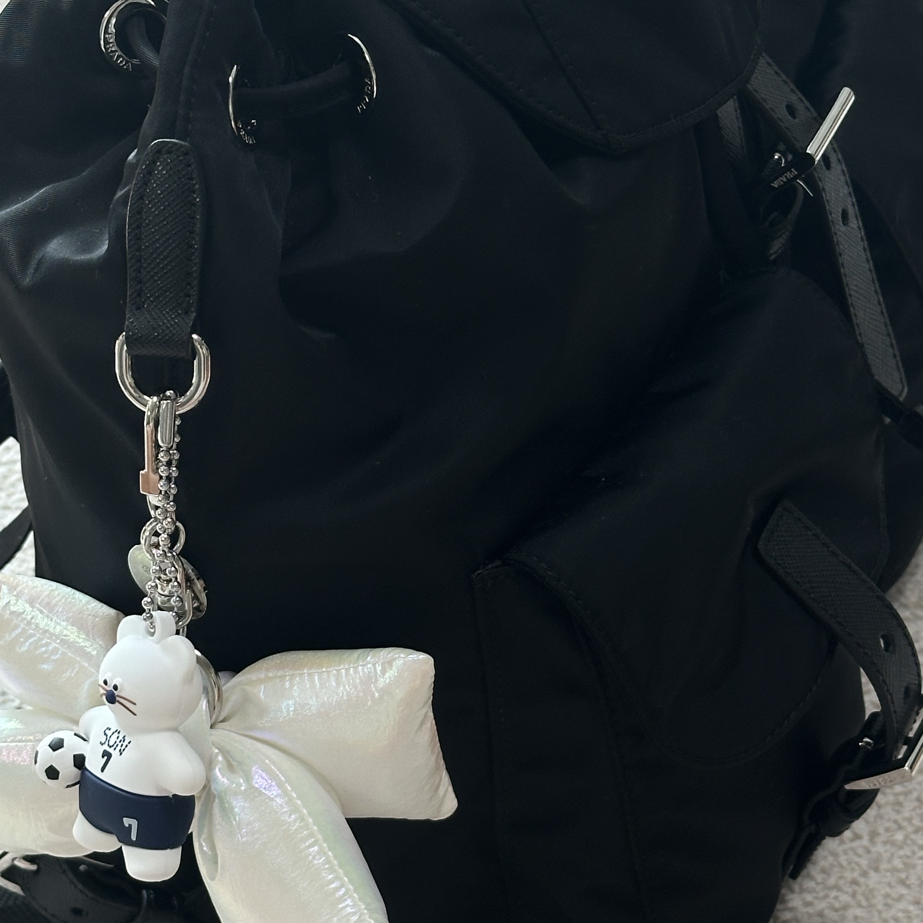 [KREAM 단독] Bloomingtale Padded Ribbon Keyring White, Prada Re-Nylon Medium Backpack Black 착용 스타일 - 1