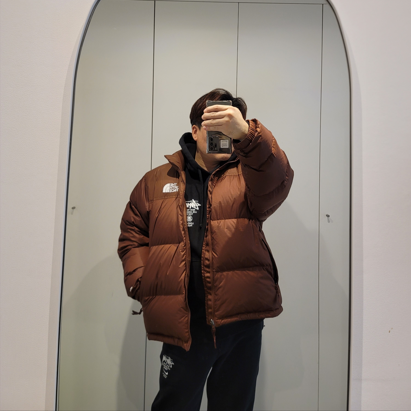 The North Face 1996 Retro Nuptse Jacket Dark Oak, Stussy World Tour Hoodie Black 2023 착용 스타일 - 1