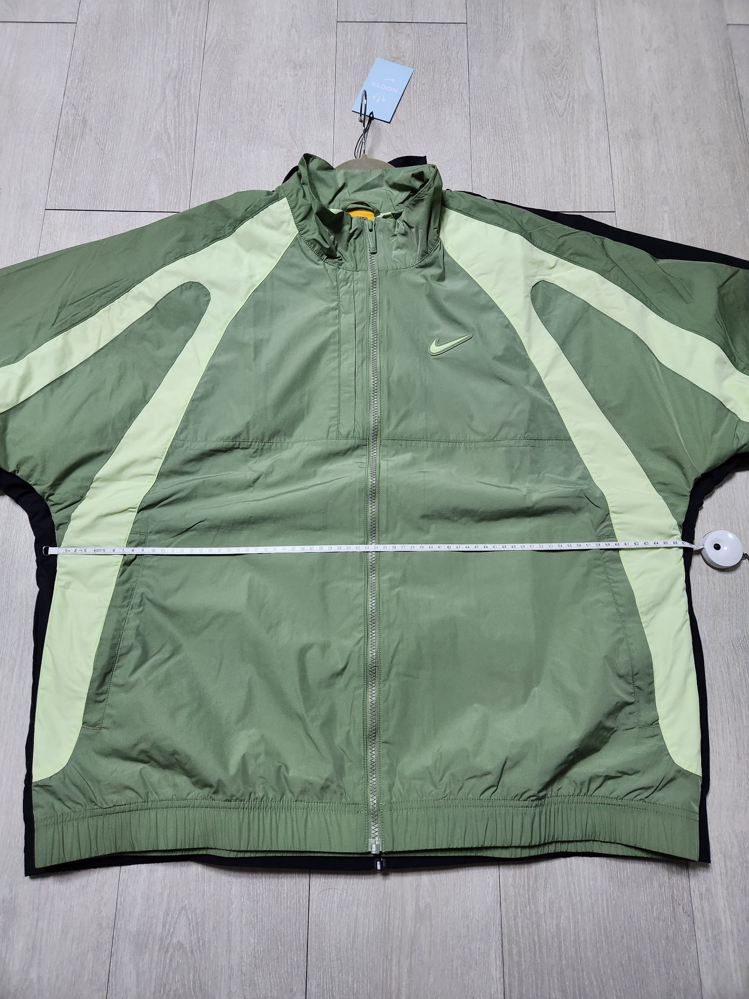 Nike x Drake Nocta Nylon Track Jacket Oil Green (FN7666-386), Nike x Drake Nocta Nylon Track Jacket Black (FN7666-010) 착용 스타일 - 1