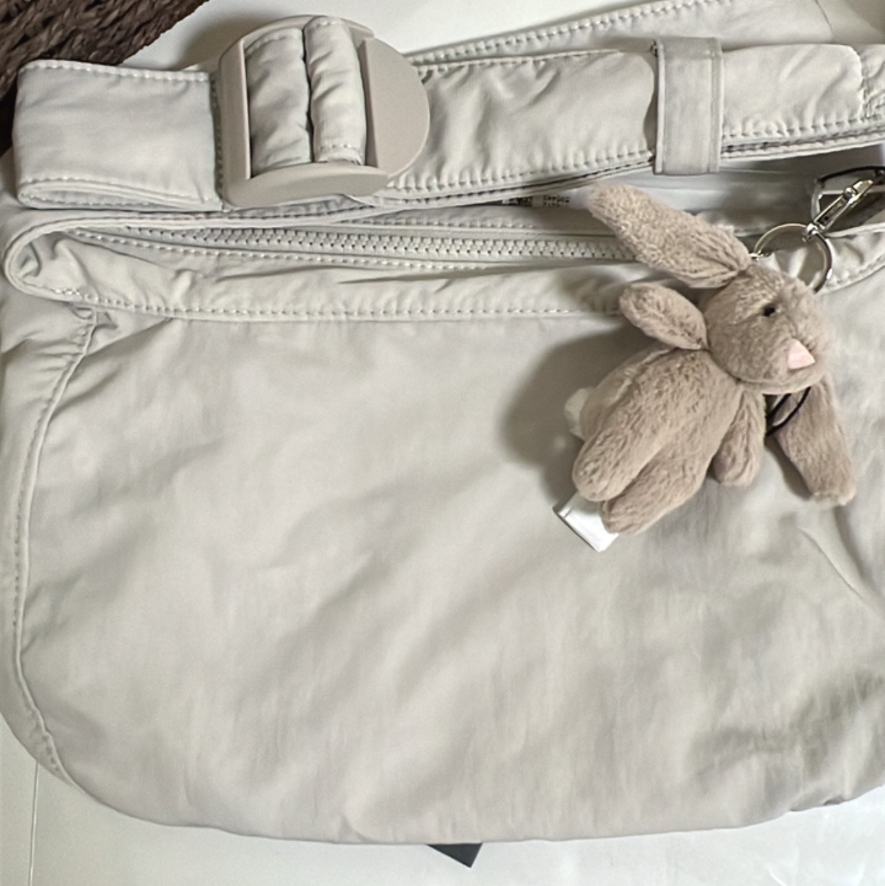 COS Nylon Crossbody Saddle Bag Light Grey Stone, Jellycat Bashful Bunny Bag Charm Beige 착용 스타일