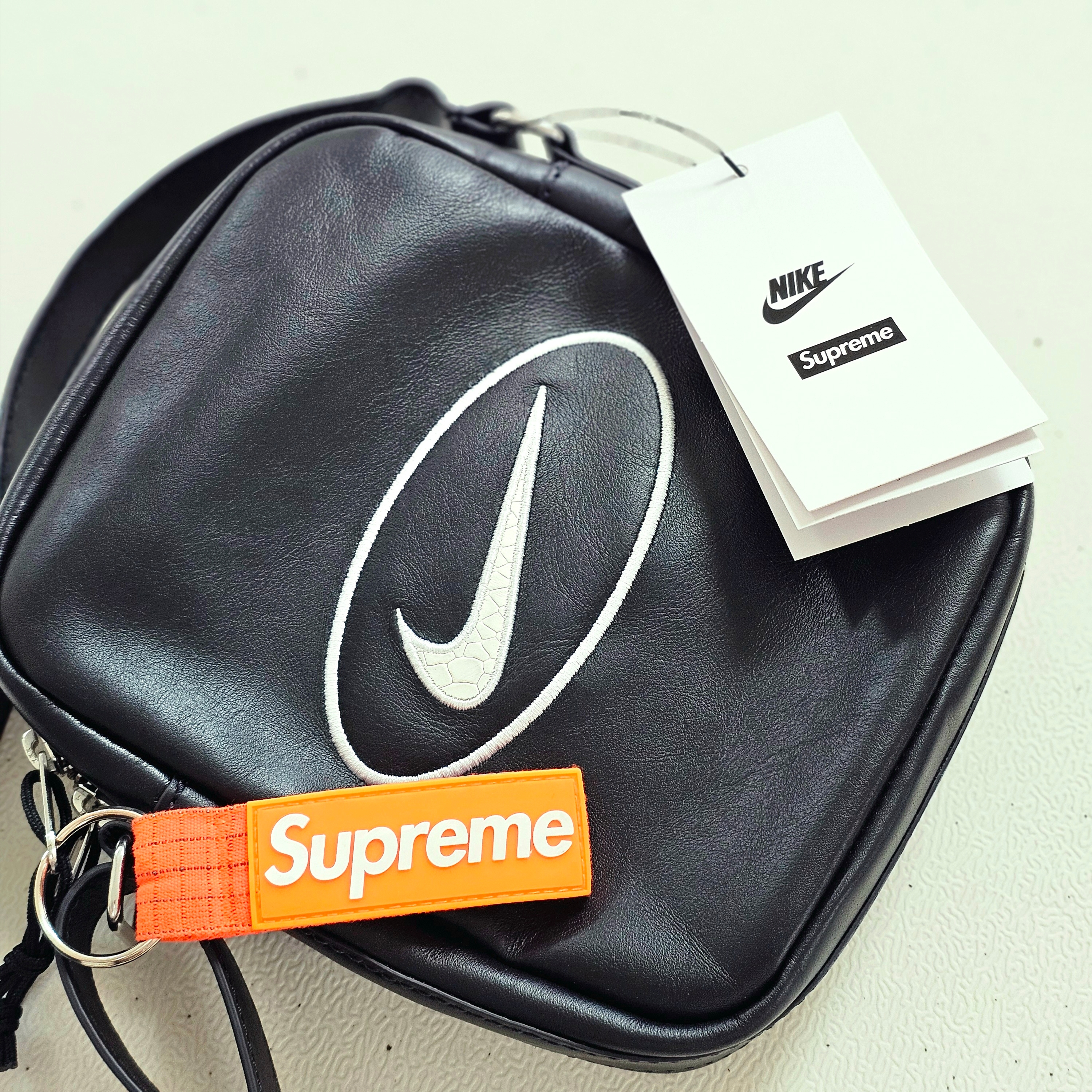 Supreme x Nike Leather Shoulder Bag Black - 25SS, Supreme Ripstop Keychain Orange - 24SS 착용 스타일 - 1