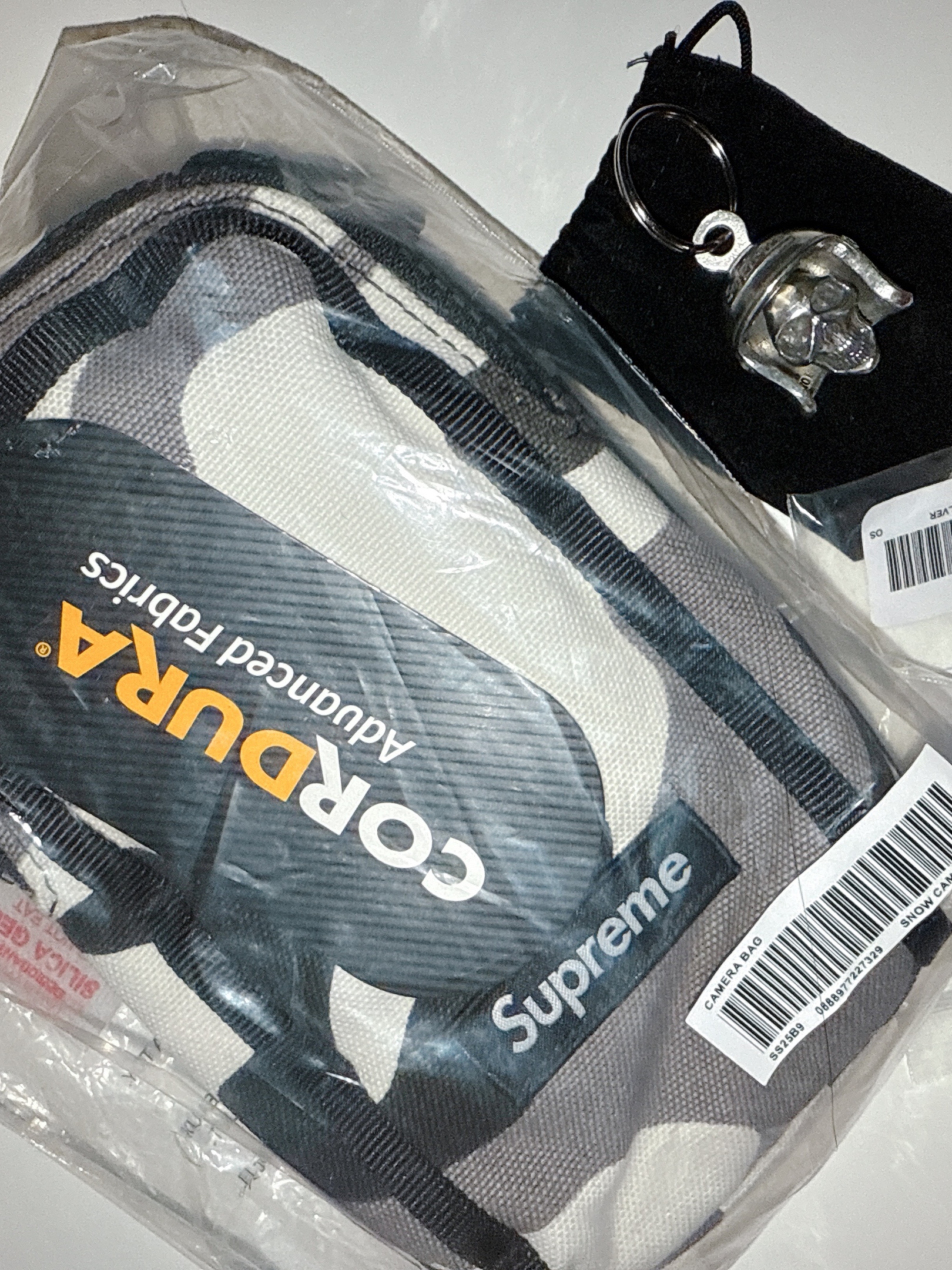 Supreme Camera Bag + Mini Pouch Snow Camo - 25SS, Supreme Skull Bell Keychain Silver - 25SS 착용 스타일