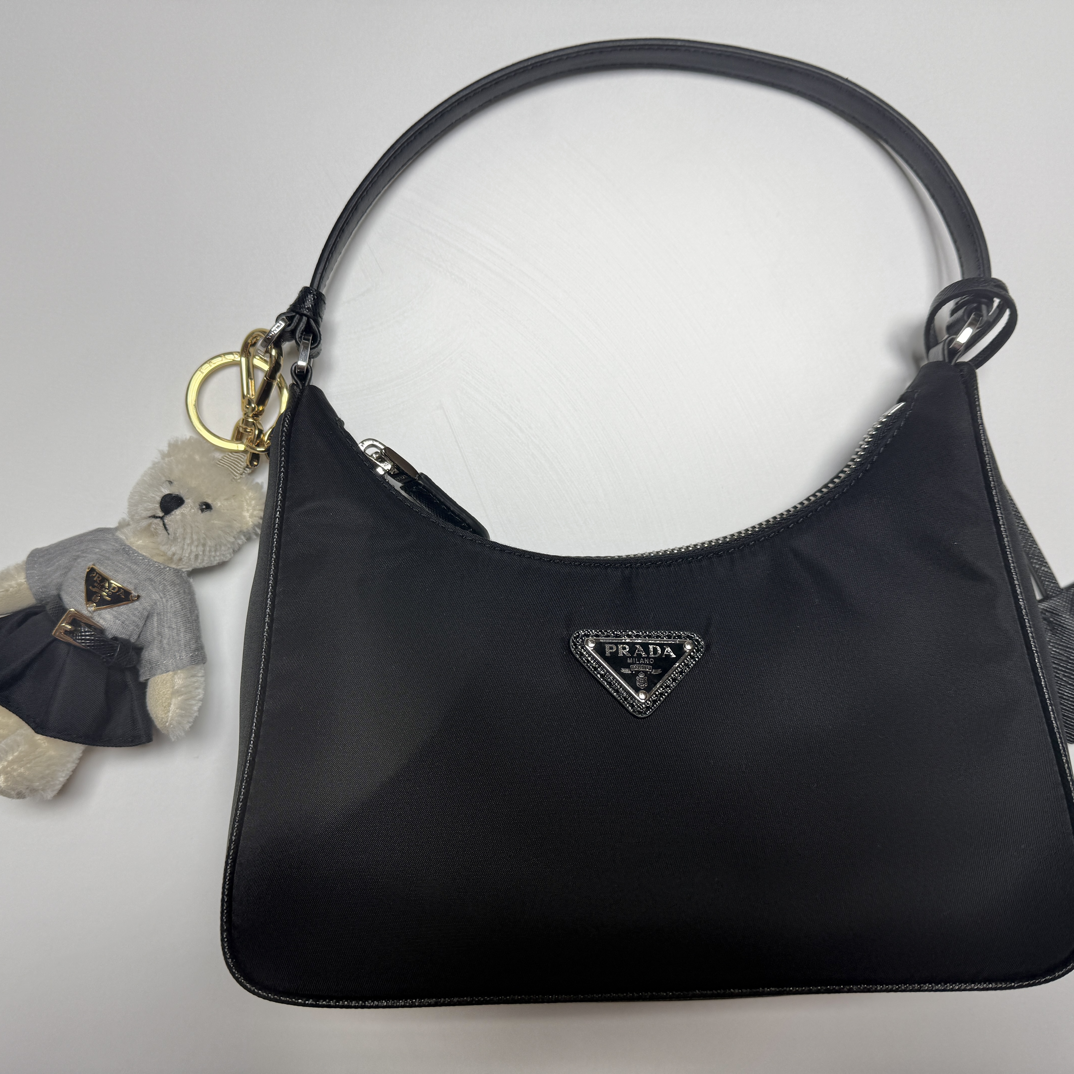 Prada Re-Edition 2005 Re-Nylon and Saffiano Mini Bag Black, Prada Teddy Bag Charm with Metal Ring White 착용 스타일