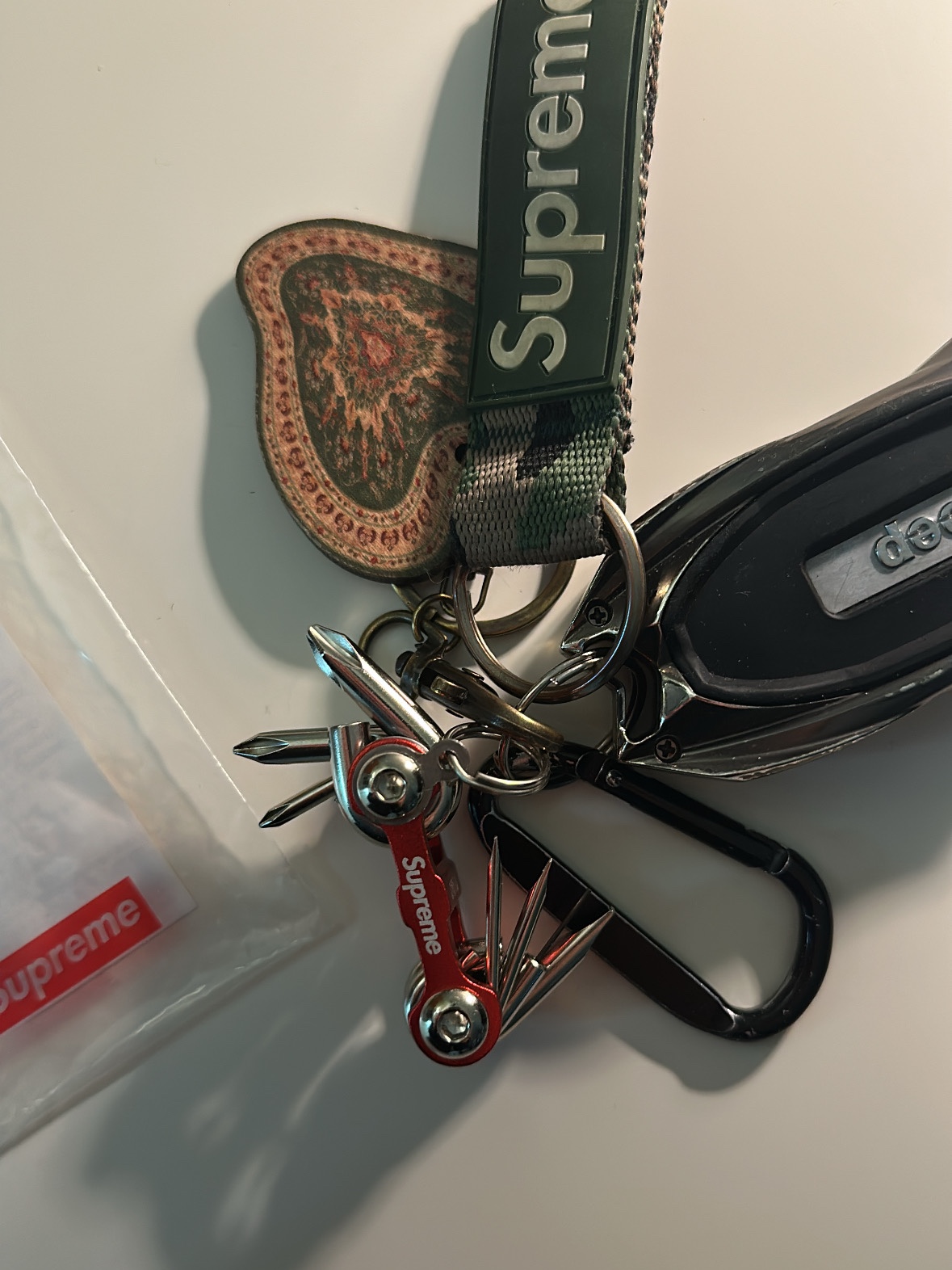 Supreme x Chibi Rib Screwdriver Keychain Red - 25FW, Supreme Webbing Keychain Green Camo - 23SS 착용 스타일