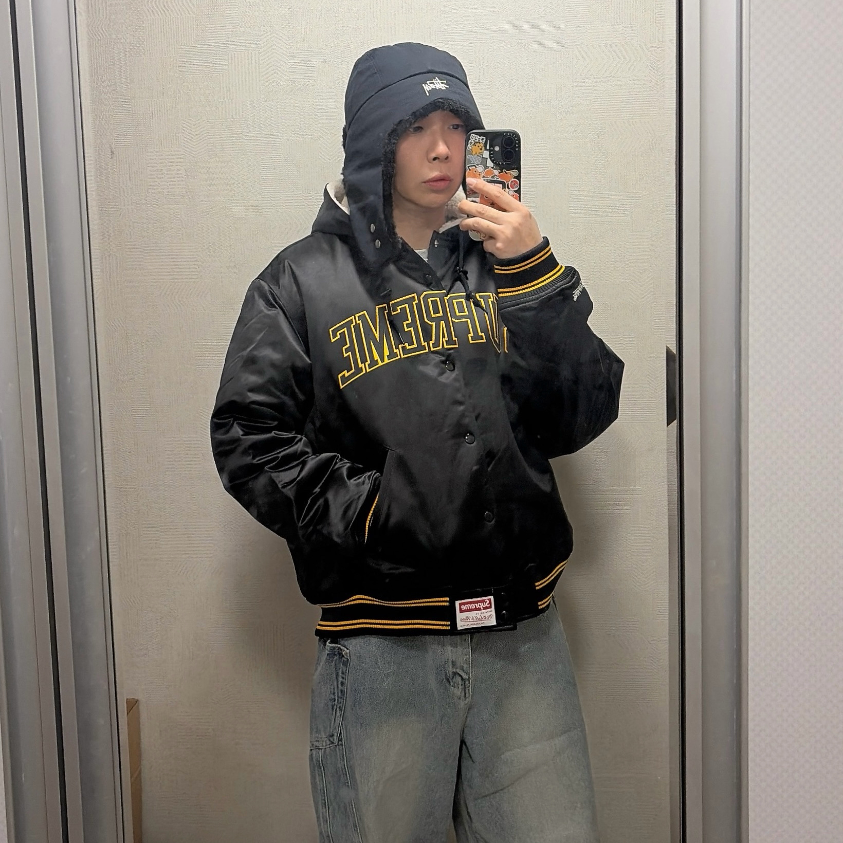 Stussy Ripstop Trapper Cap Black, Supreme Mitchell & Ness Lined Hooded Satin Varsity Jacket Black - 25FW 착용 스타일