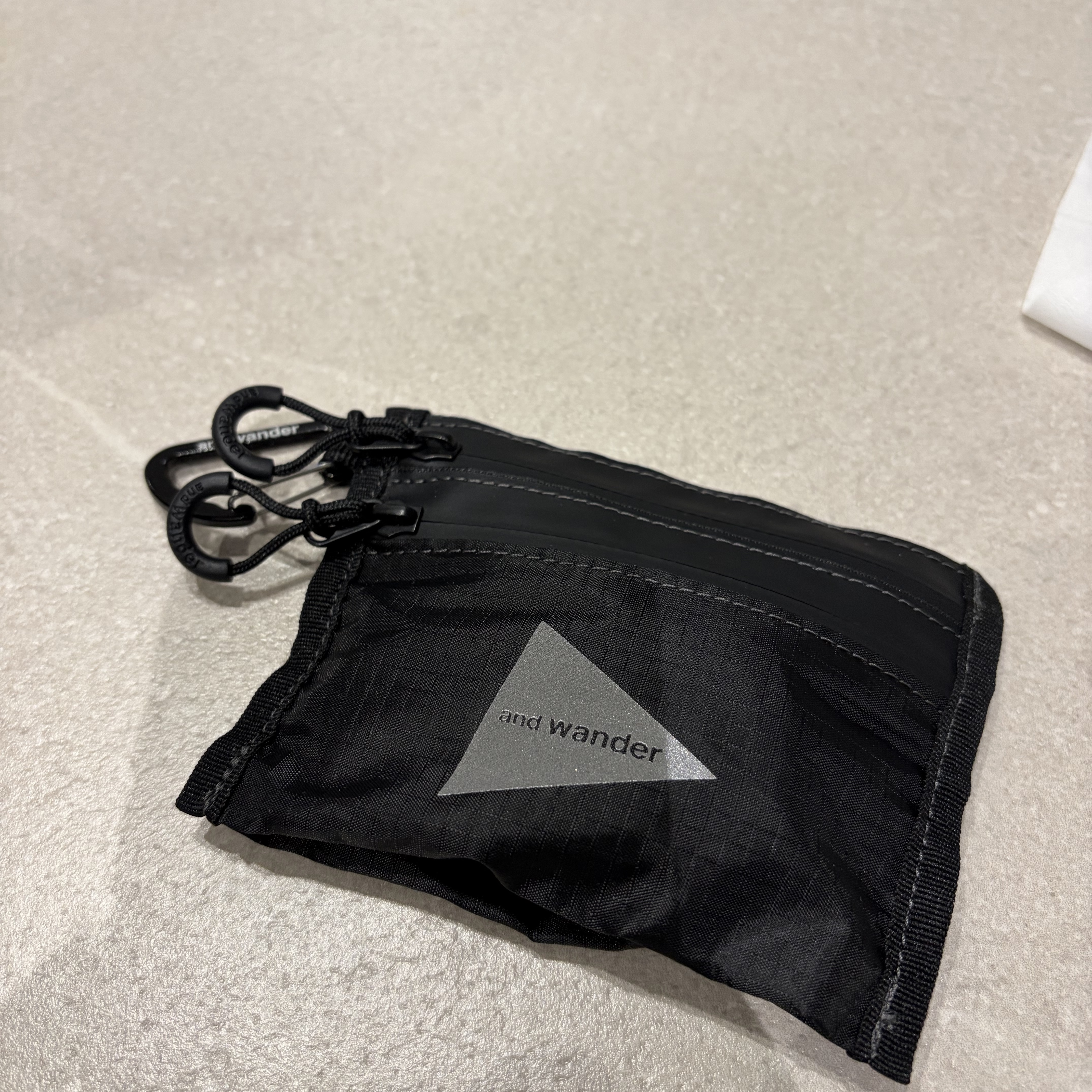 And Wander 150 Crispy Rip Mini Twin Pouch Black - 26SS 착용 스타일