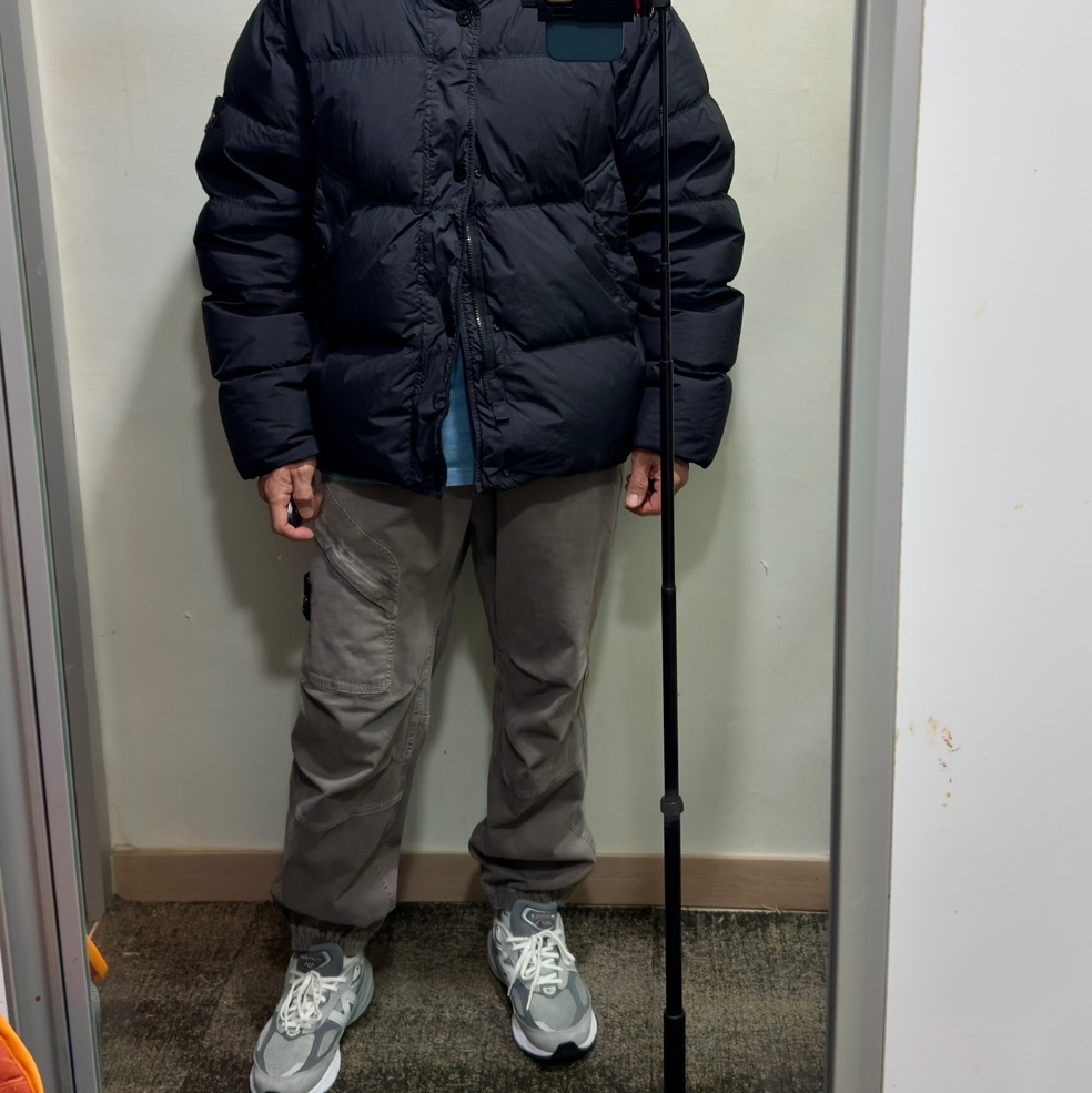 Stone Island 4100010 Crinkle Reps NY Recycled Nylon Down Jacket with Wind Resistant Black - 25FW, Stone Island 3100036 Stretch Organic Broken Twill Cotton Old Effect Loose Fit Jogger Trousers with Snap and Zip Pockets Cement - 25FW 착용 스타일 - 2