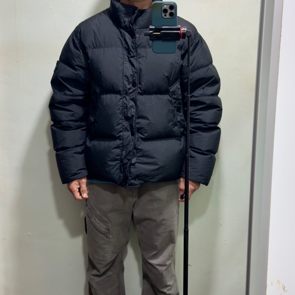 Stone Island 4100010 Crinkle Reps NY Recycled Nylon Down Jacket with Wind Resistant Black - 25FW, Stone Island 3100036 Stretch Organic Broken Twill Cotton Old Effect Loose Fit Jogger Trousers with Snap and Zip Pockets Cement - 25FW 착용 스타일 - 1