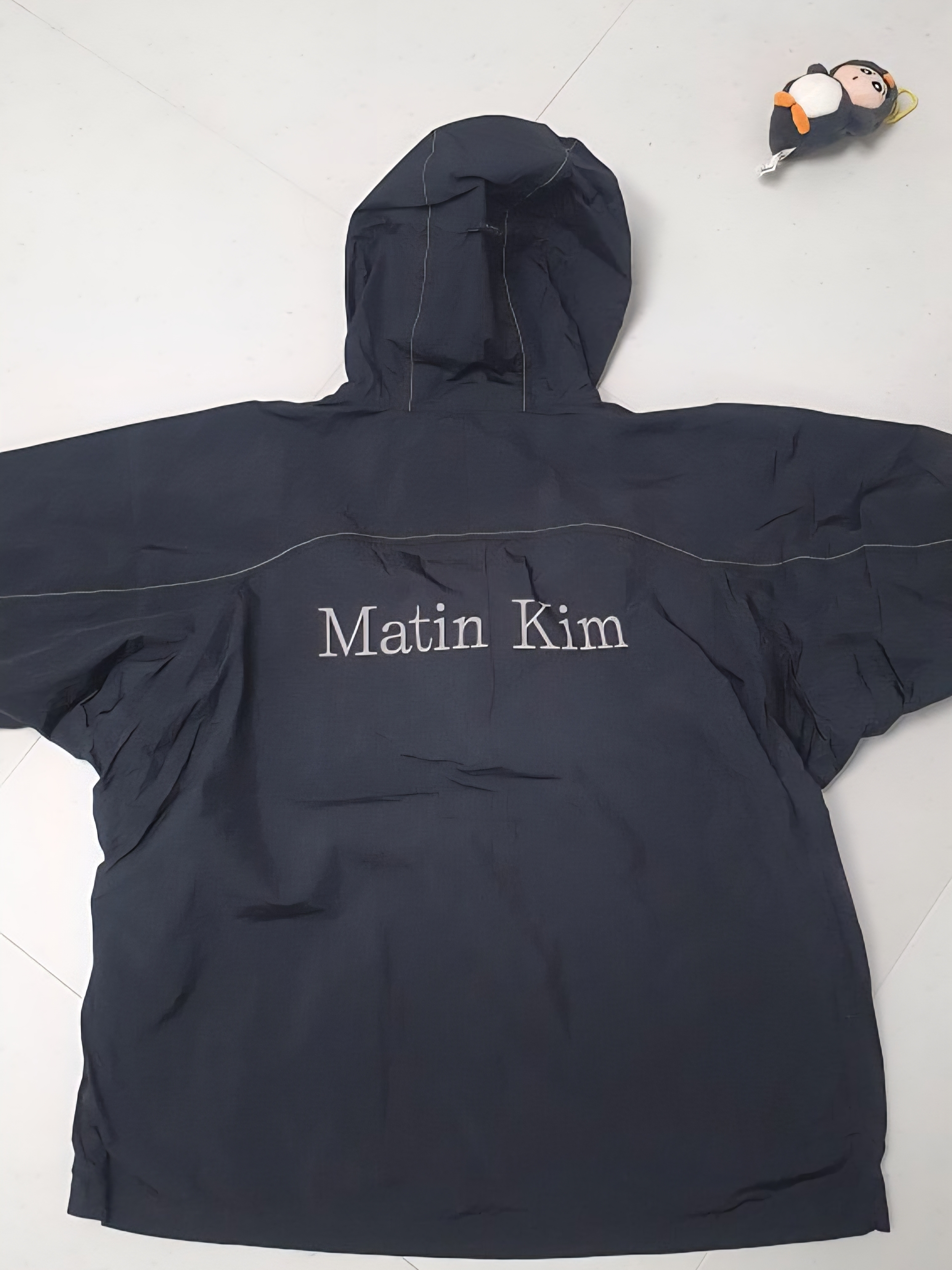 Matin Kim Back Logo Hoody Wind Breaker In Black 착용 스타일 - 1